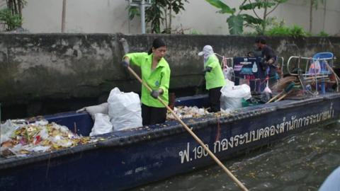 People cleaning up a canal in Bangkok