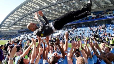 Pep Guardiola is thrown into the air by his Manchester City players