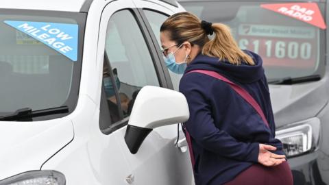 Woman browsing cars in a showroom