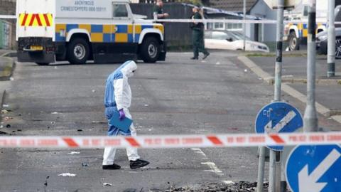 A forensic officer examines the scene of the violence in Londonderry
