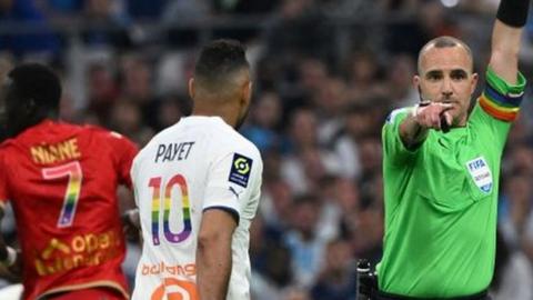 Referee Benoit Millot wearing a LGBTQIA+ rainbow-coloured armband during Marseille's game with Angers on 14 May 2023