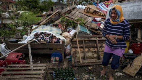 Woman near battered buildings in the Philippines after Typhoon Mangkhut, 15 September 2018