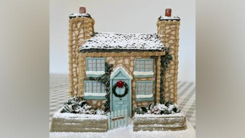 Photo of a cake made by Bridie West, the cake baker from Essex has gone viral on TikTok after making an "entirely edible" version of the cottage from the Christmas film The Holiday.