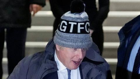 Boris John leaving the Covid inquiry in London in a hat with the initials GTFC
