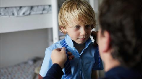 Child being dressed for school