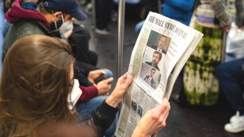 A passenger reads the front page of the Wall Street Journal reporting on tech company executives testifying to a congressional committee investigating monopoly policies on October 29, 2020