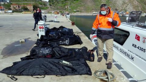 A rescuer walks next to bodies of refugees and migrants in body bags laid on a pier next to a Turkish coast guard vessel, after an inflatable boat carrying refugees and migrants sank off the Greek island of Lesbos and at least 16 people drowned, at the Aegean port village of Babakale in Canakkale province, Turkey, 24 April 2017