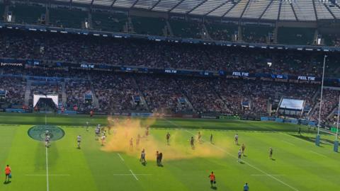 Protestors let off orange smoke bombs