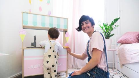 A woman and child stand next to wall stickers