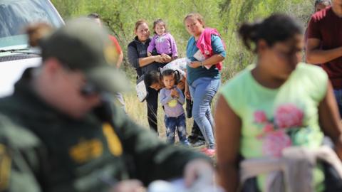 Central American asylum seekers wait as US Border Patrol agents take them into custody near McAllen, Texas.