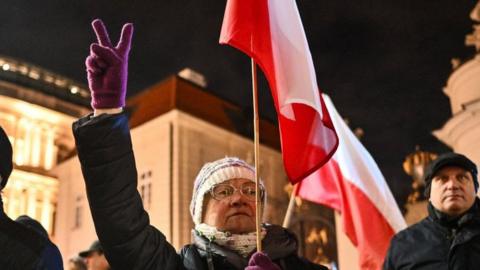People hold banners and shout slogans as they take part in a protest against a warrant for the former Minister of the Interior of Poland in front of the Presidential Palace in Warsaw, Poland on January 09, 2024