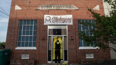 Norman Brooks covers the door of the Mahogany Masterpiece dance studio, the scene of last night's deadly mass shooting, on April 16, 2023 in Dadeville, Alabama.