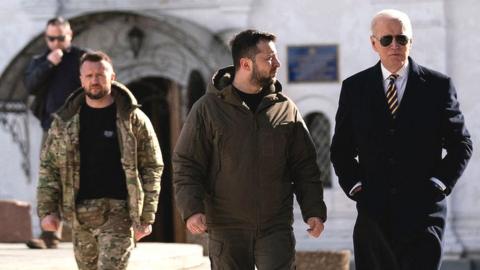 US President Joe Biden (r) walks with Ukrainian President Volodymyr Zelensky (C) at St. Michael's Golden-Domed Cathedral during an unannounced visit, in Kyiv on February 20, 2023