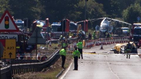 Police and members of the emergency services work at the scene of a plane crash at Shoreham airfair in Shoreham