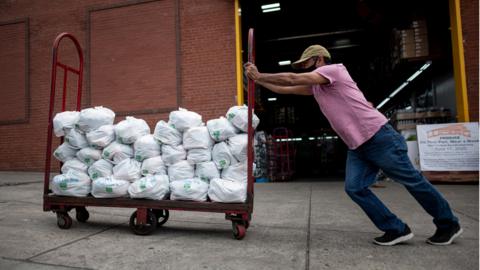 Felix Pinzon, an unemployed construction worker pushes a cart of food delivery donations on May 19, 2020 in the Bronx borough of New York City.