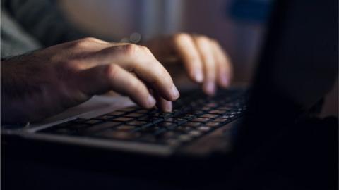 A man typing on a computer keyboard