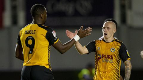 Omar Bogle of Newport County celebrates scoring his side's first goal from the penalty spot with James Waite