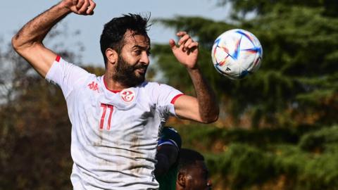 Tunisia forward Taha Yassine Khenissi goes for a header against Comoros