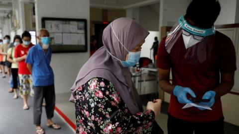 Residents of a public housing estate queue up for mandatory coronavirus swab tests in Singapore May 21, 2021