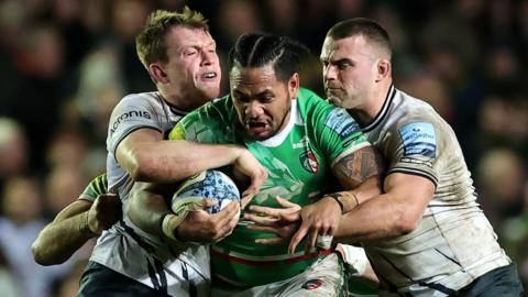 Leicester's Solome Kata is held by Saracens' Ben Earl (right) and Nick Tompkins