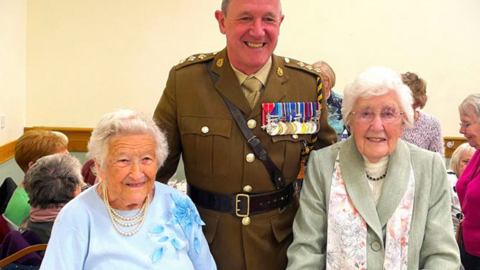 Kath Morris and Gwenfron Picken with Captain Huw Williams in military uniform standing behind them