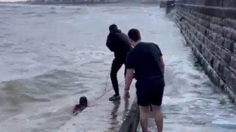 Men rescue person from sea