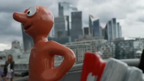 Orange Morph statue in front of London skyline