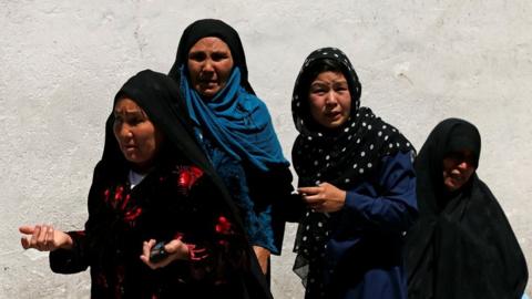 Relatives of the victims mourn at a hospital after a suicide attack in Kabul, Afghanistan, 22 April