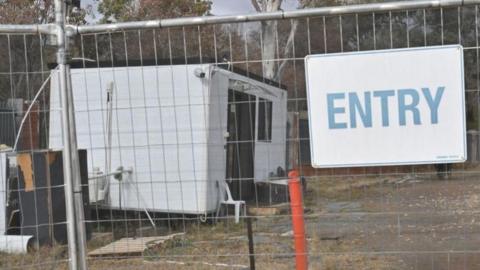 A demountable building behind a gate on the Russian embassy work site