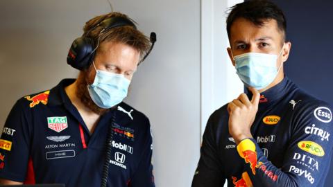 Alex Albon and a Red Bull engineer wear face masks