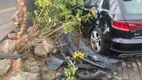 A damaged car and wall in Luton