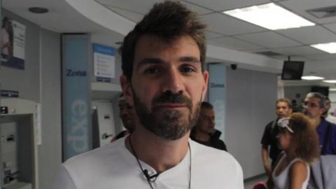 Guillermo Olmo pictured reporting from a bank in Caracas