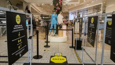 Signage reminding shoppers of social distancing rules in a River Island store in Liverpool, as shops make preparations to reopen following the introduction of measures to bring England out of lockdown.