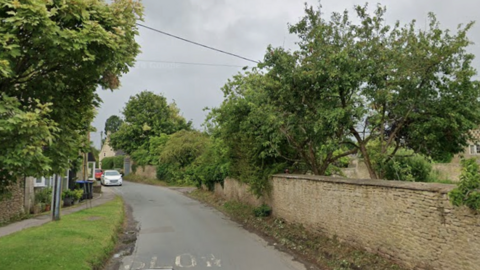 A google street view image of Atworth showing trees and a brick wall