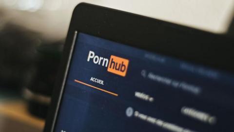 The French homepage of Pornhub on a laptop screen, showing the company logo
