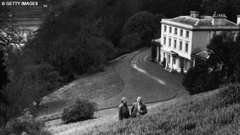 Dame Agatha Christie, and her husband Max E. L. Mallowan, pose in March 1946 in the ground of their home, Greenway House, in Devonshire.