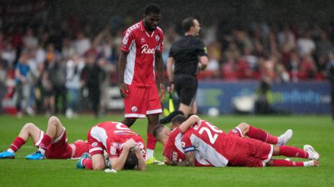 Crawley Town players celebrate after securing survival