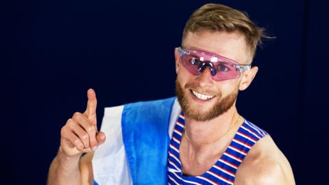 Josh Kerr poses with a Saltire flag
