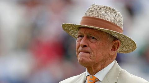 Sir Geoffrey Boycott, pictured wearing a boater hat and beige suit.