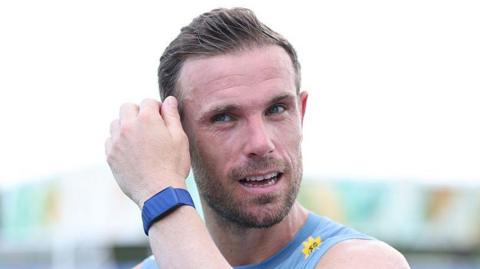Jordan Henderson mops his brow during an England training session
