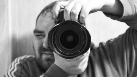 Photographer Neil Catley holds up a camera