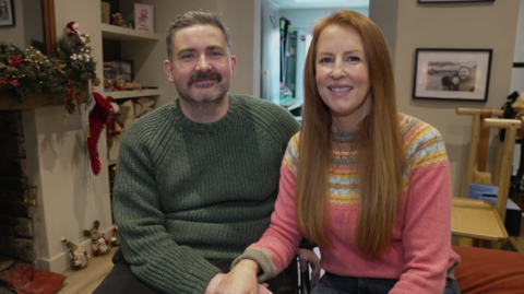 Dan ac Anna yn eu cartref, yn gwenu