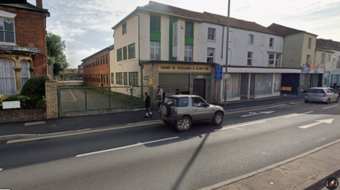 A gateway next to some empty buildings on a main road