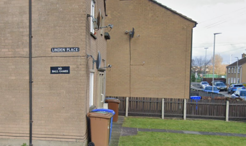 A beige building with a Linden Place sign on it