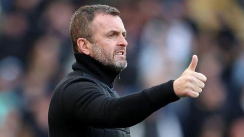 Nathan Jones gives a thumbs up while stood on the sidelines
