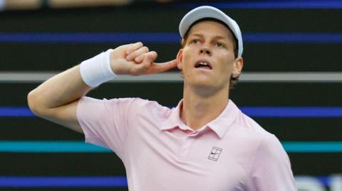 Jannik Sinner puts his hand to his ear