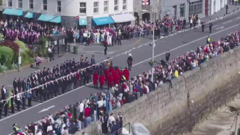 The image shows crowds gathering in St Peter Port for Liberation Day.