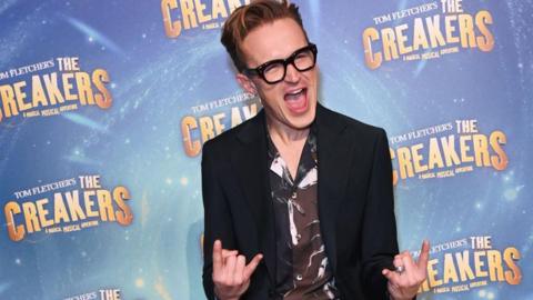 Tom Fletcher making a rock and roll sign