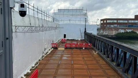 A white tarpaulin and scaffolding cover large parts of the structure