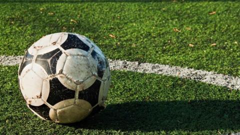 A football on an astroturf pitch.